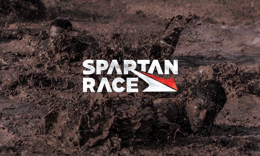 Man swimming through muddy waters as a background for the Spartan Race concept logo refresh