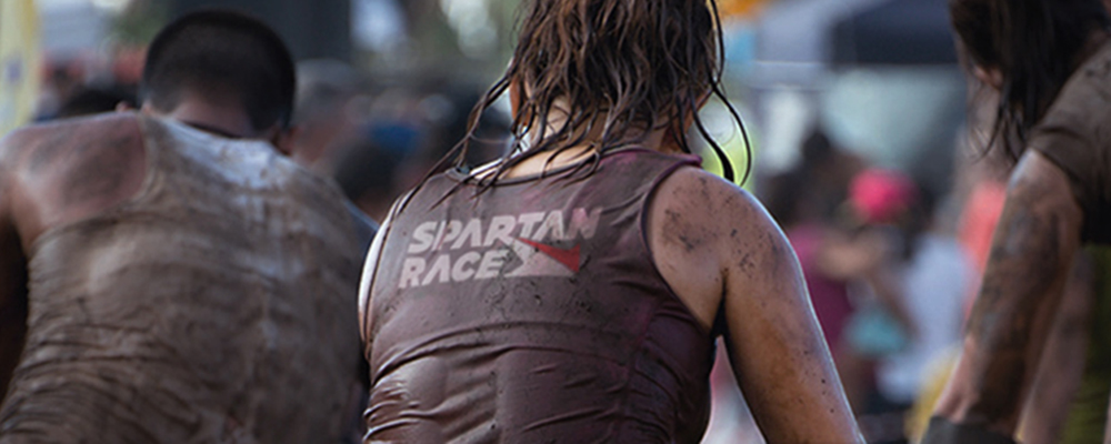 Girl running race in Spartan Race branded top
